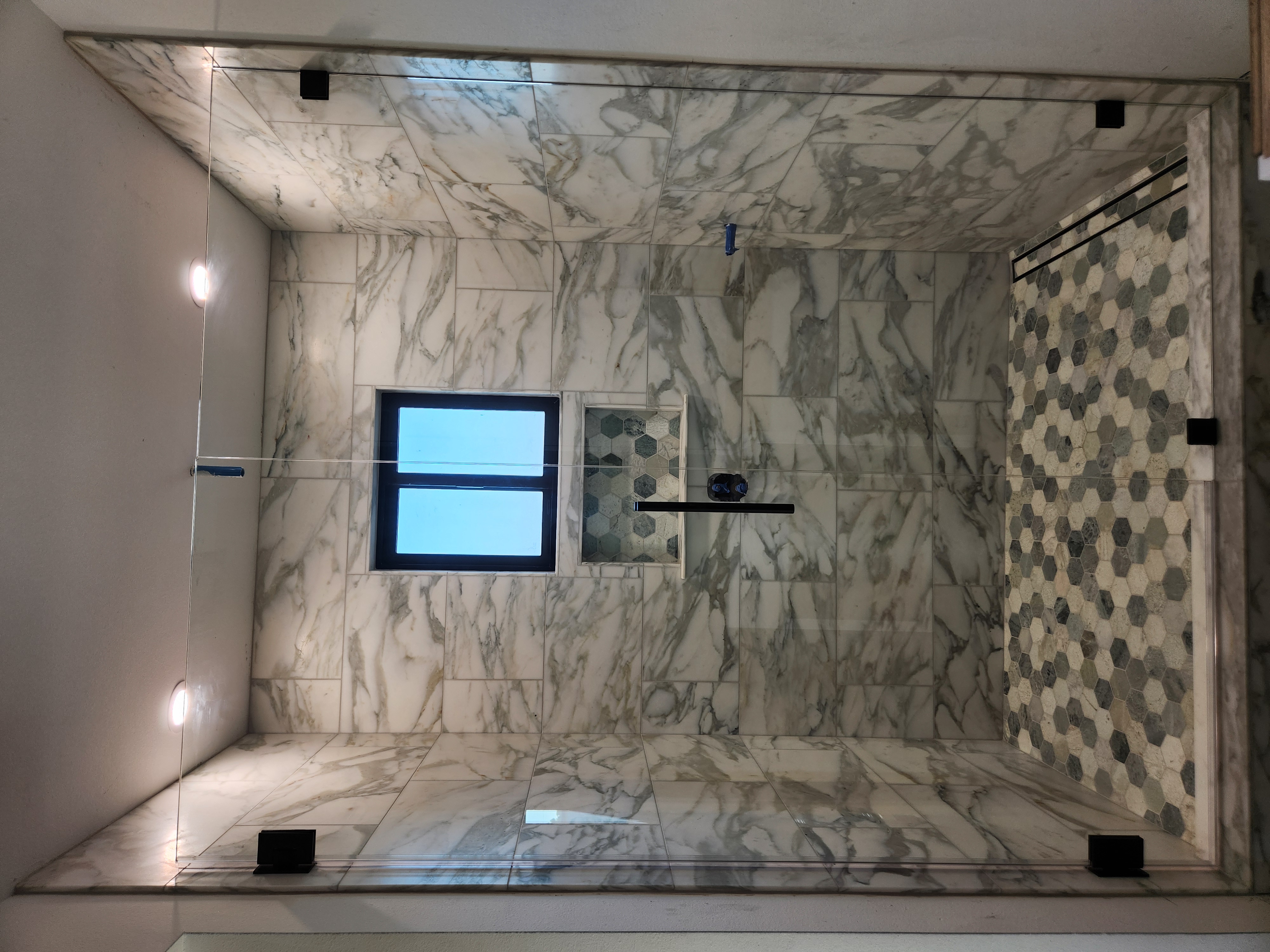 Detailed marble tile installation inside a custom shower