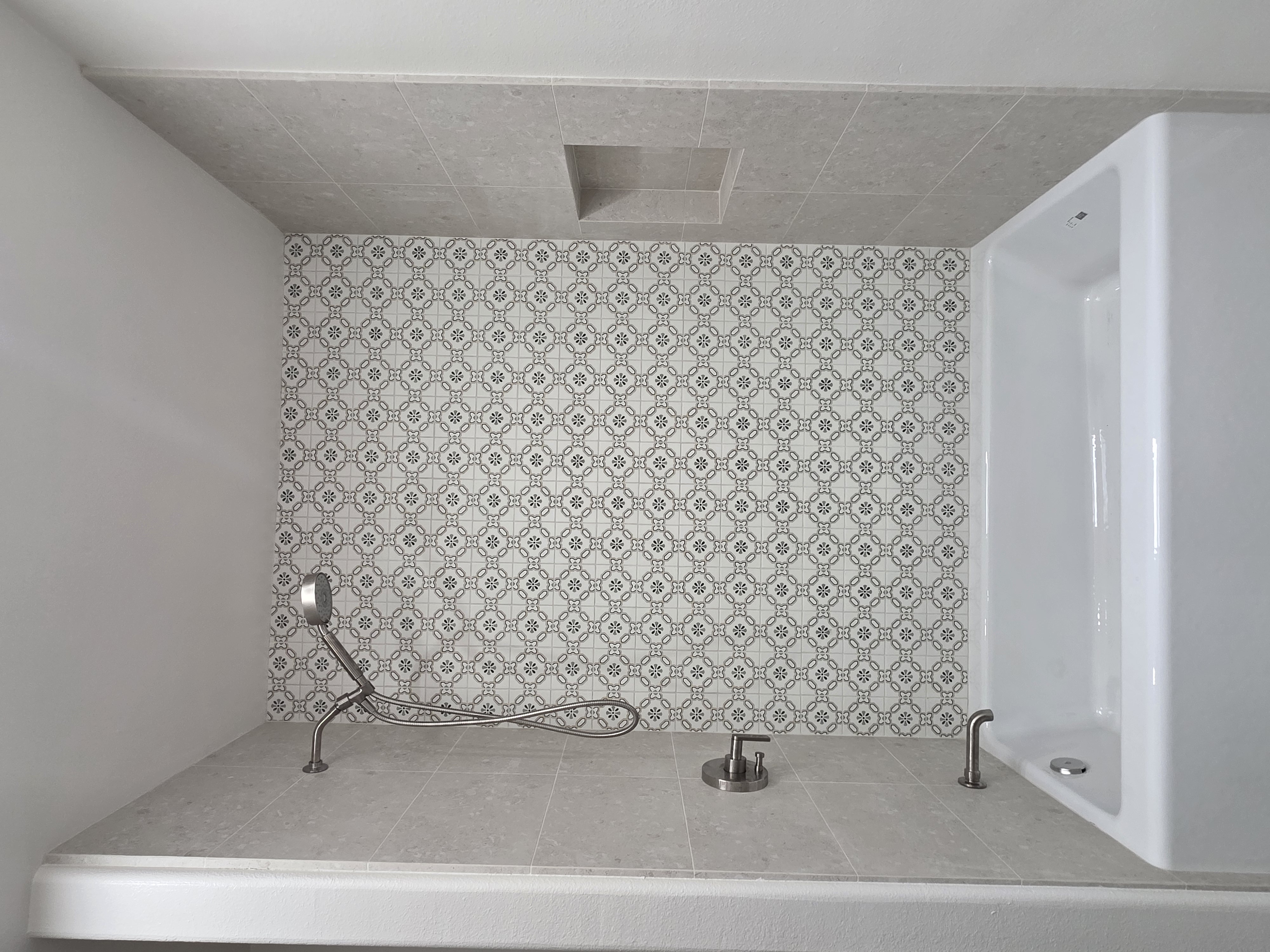 Completed bathroom with patterned feature tile above the tub
